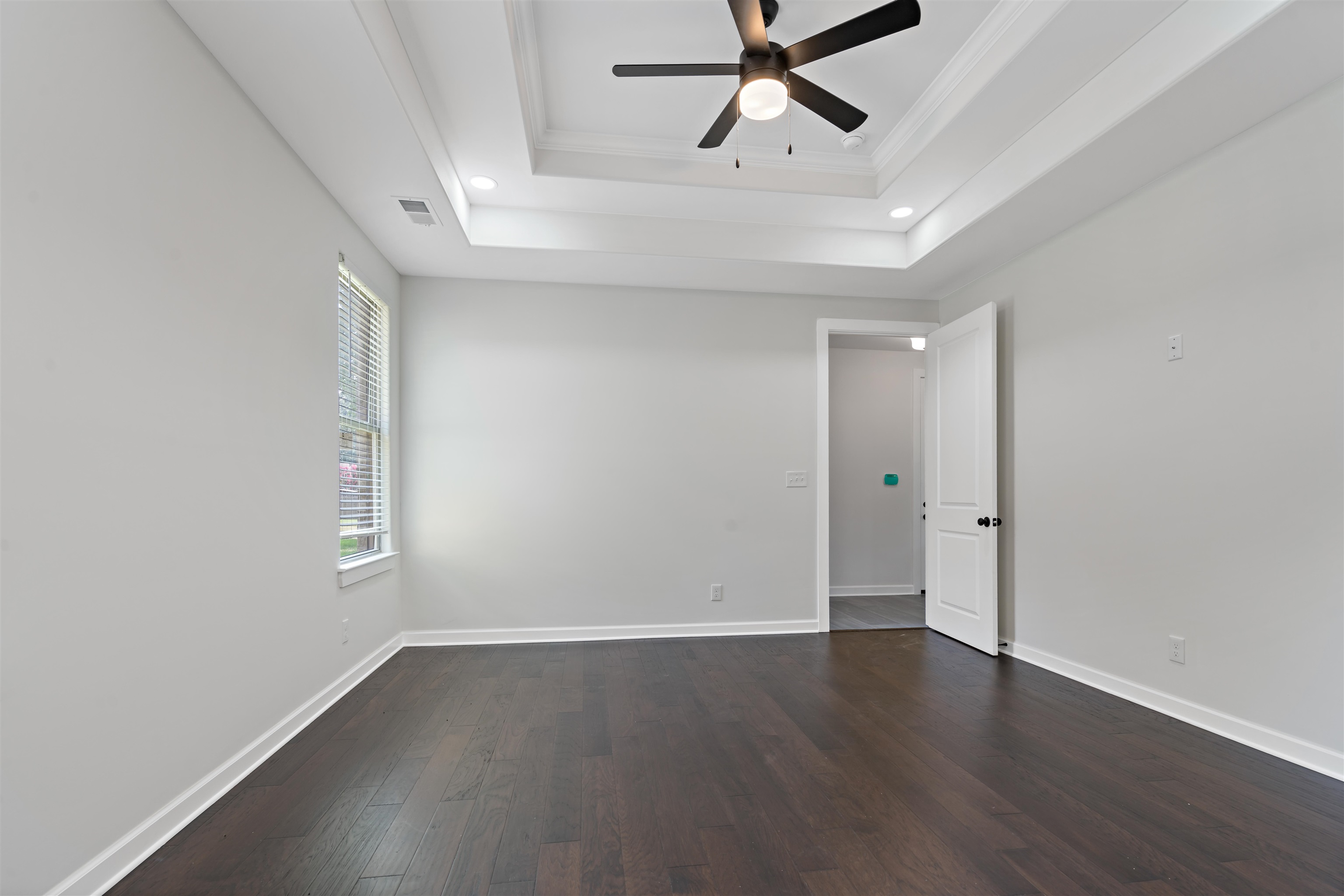 694 Brownlee Road Memphis, TN 38116 - Photo 8 of 15 Spare room featuring wood-type flooring, ceiling fan, a raised ceiling, and crown molding
