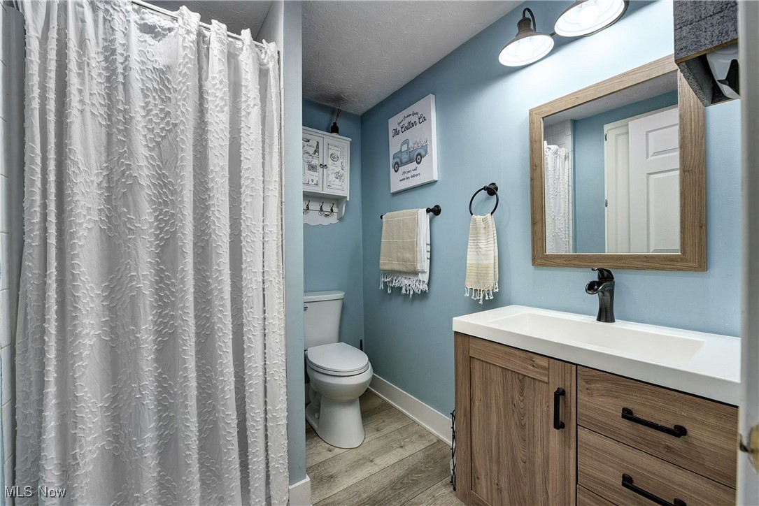 5927 Highland Road Highland Heights, OH 44143 - Photo 9 of 22 Bathroom featuring vanity, toilet, wood-type flooring, and a textured ceiling