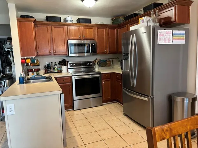 a kitchen with stainless steel appliances granite countertop a refrigerator stove and microwave