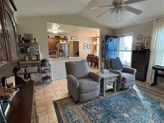 a living room with furniture a chandelier and a dining table with wooden floor