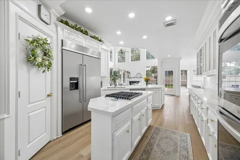 a kitchen with stainless steel appliances granite countertop a refrigerator a stove and a wooden floors