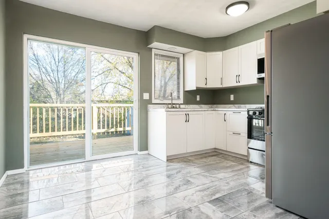 a kitchen with granite countertop a stove a sink and a refrigerator