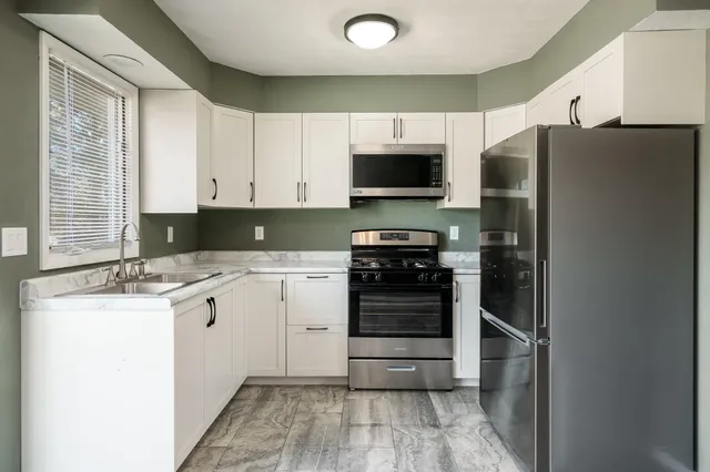 a kitchen with stainless steel appliances a stove sink and refrigerator