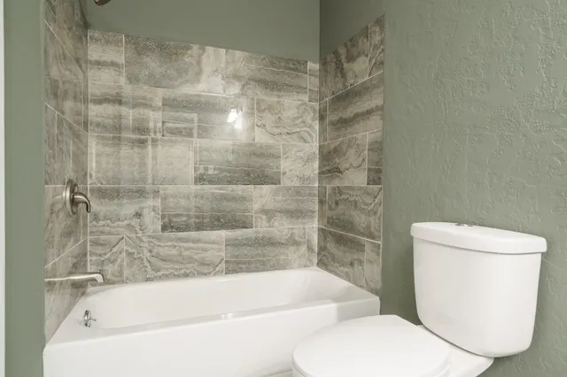 a white bath tub sitting next to a toilet