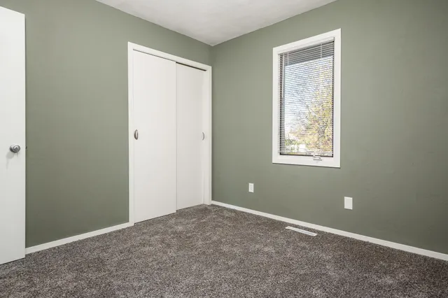 an empty room with windows and closet