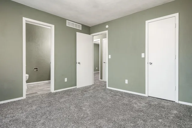 a view of an empty room with closet and entryway