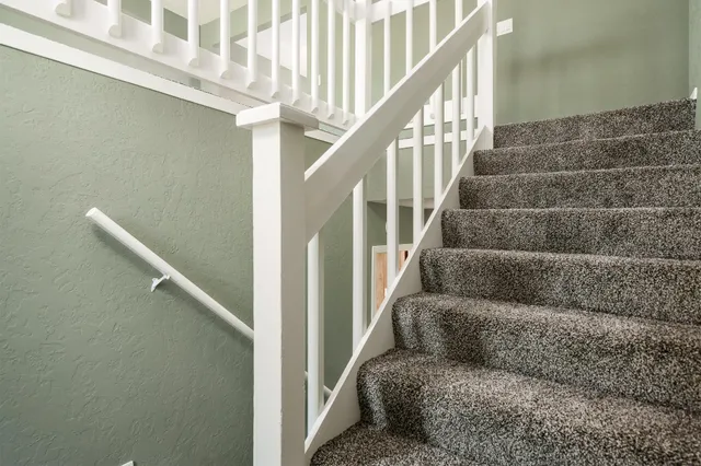 a living room with furniture and stairs