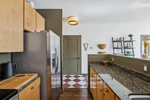 a kitchen with stainless steel appliances granite countertop a refrigerator and a stove