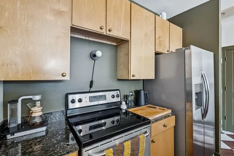 a kitchen with stainless steel appliances granite countertop a stove a refrigerator and a microwave