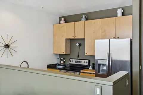 a kitchen with stainless steel appliances a refrigerator sink and white cabinets