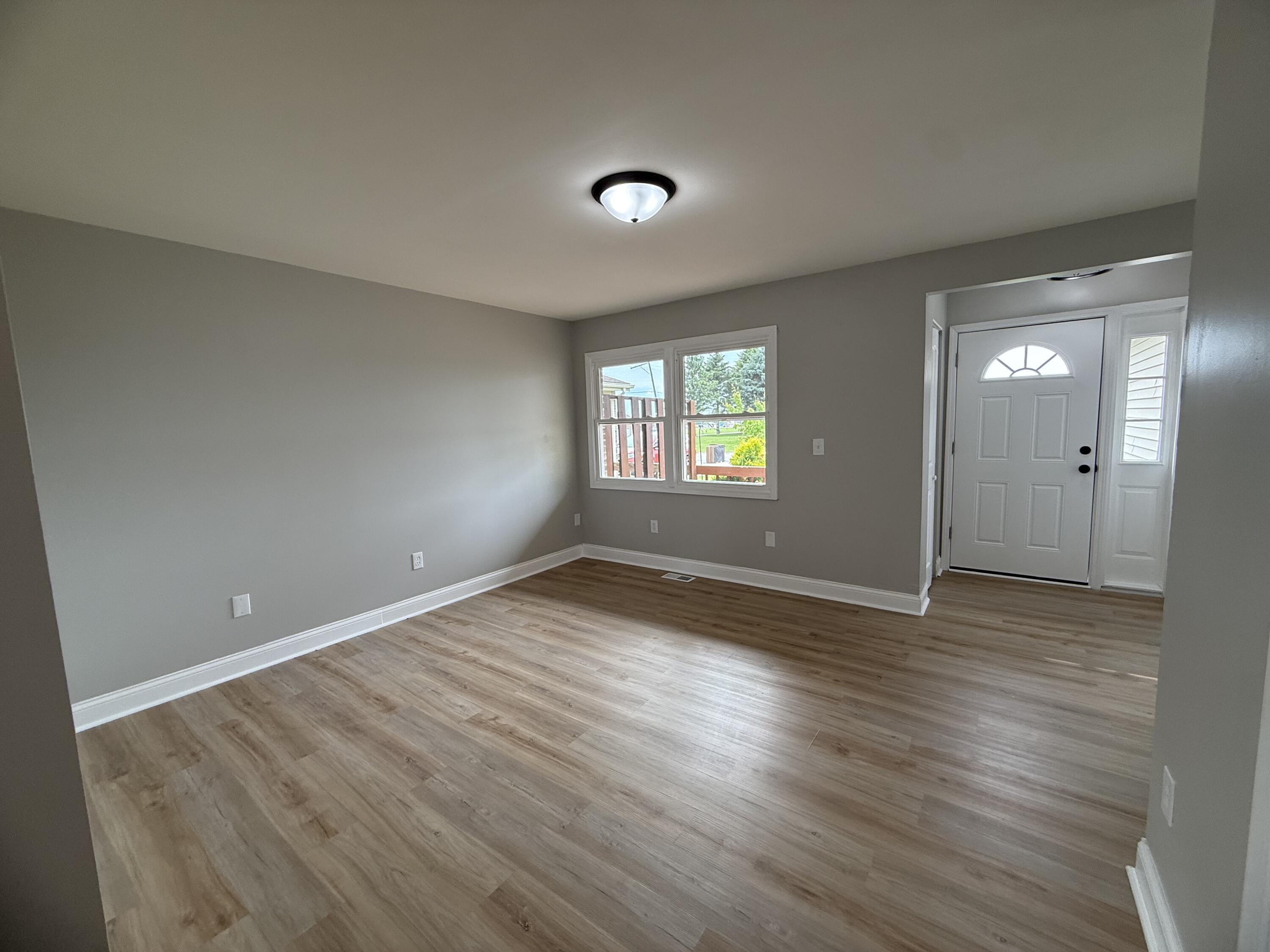 15895 Sherman Street Lowell, IN 46356 - Photo 8 of 36 an empty room with wooden floor and windows