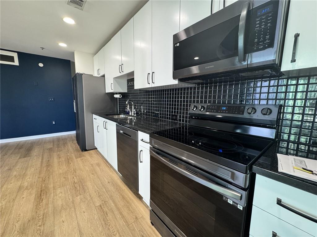 250 Pharr Road Northeast, Unit 601 Atlanta, GA 30305 - Photo 7 of 34 a kitchen with stainless steel appliances wooden cabinets and stove
