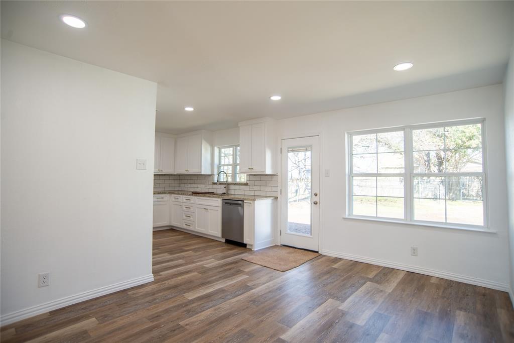1805 Belden Street Sherman, TX 75092 - Photo 4 of 16 a kitchen with granite countertop white cabinets and wooden floor