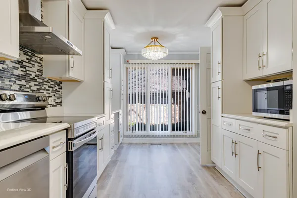a kitchen with cabinets and wooden floor