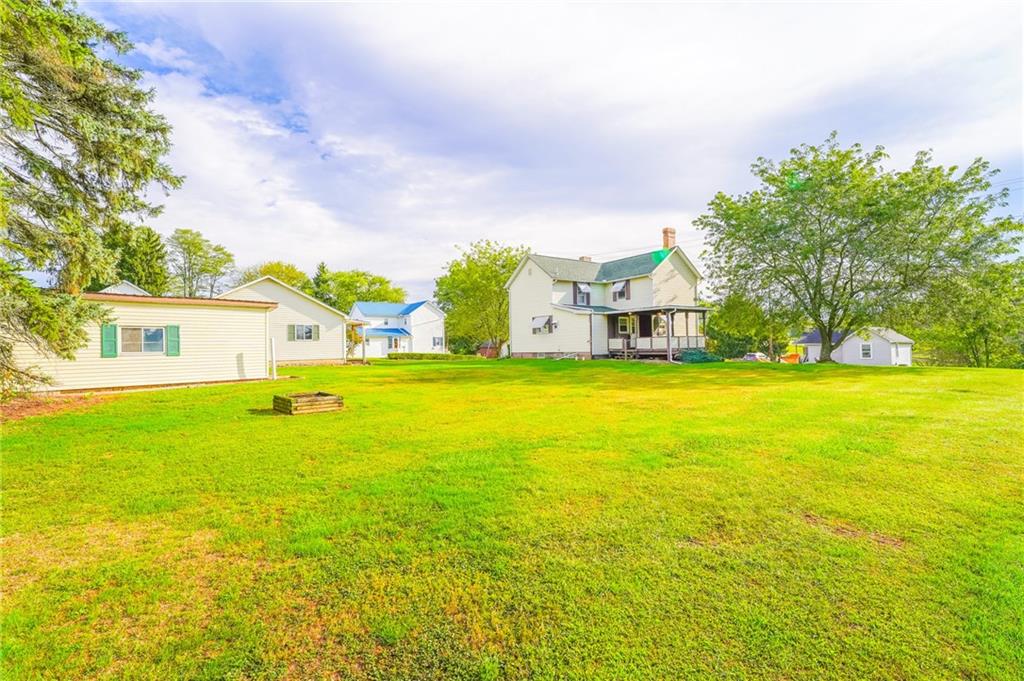 6304 Tuscarawas Road Midland, PA 15059 - Photo 10 of 49 a view of a house with a big yard and large trees