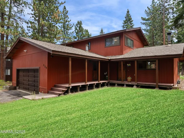 a view of a house with a yard and large tree