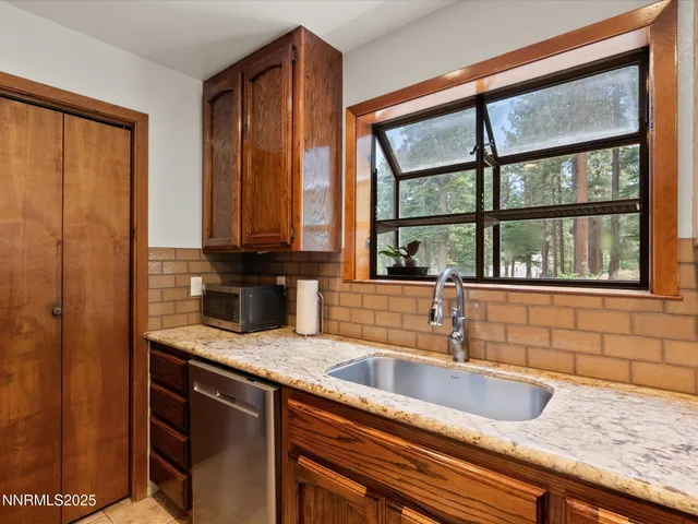 a kitchen with kitchen island granite countertop a sink refrigerator stove and microwave
