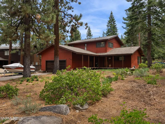 a front view of house with yard and trees around