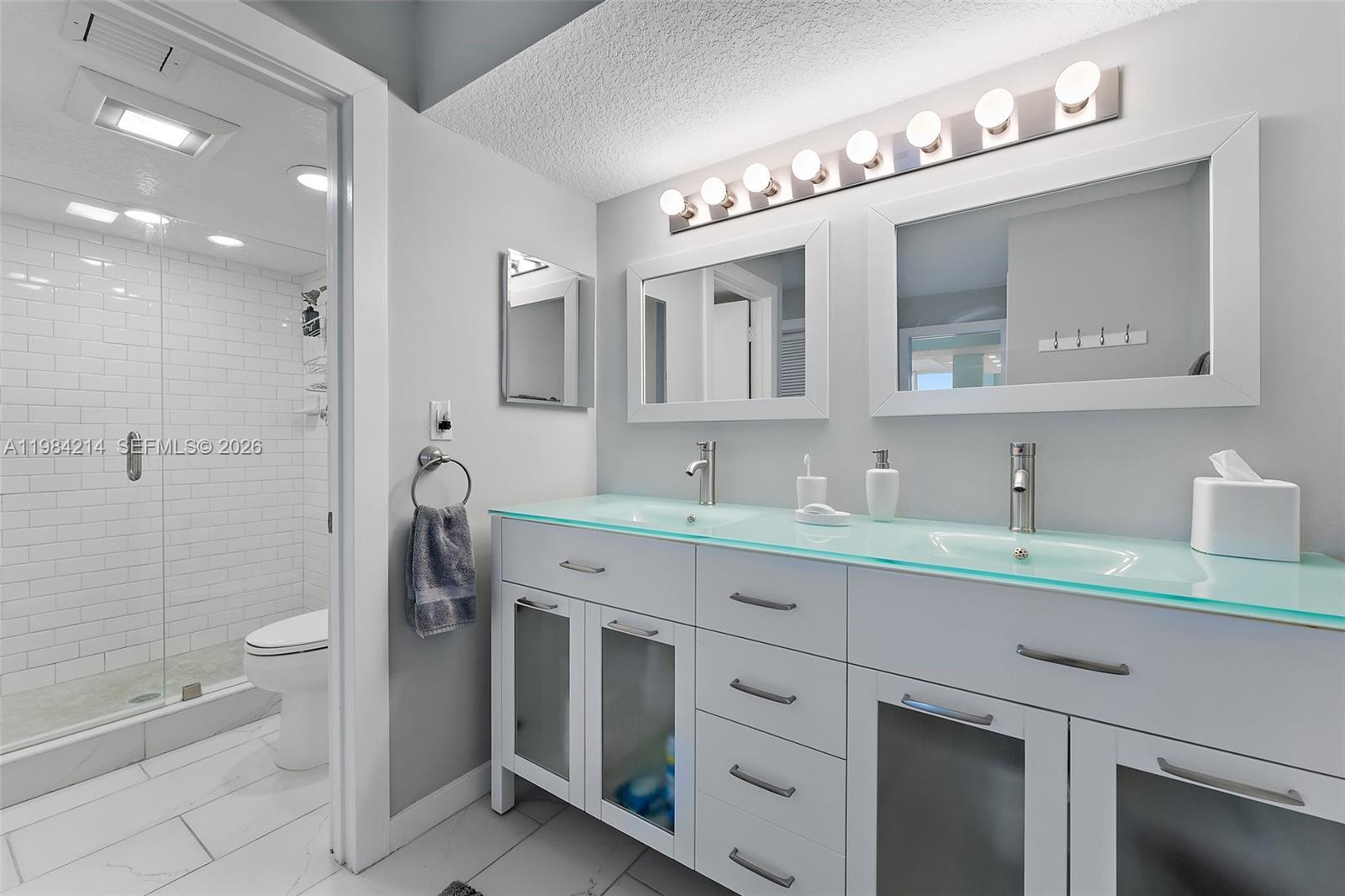 669 Northeast Plantation Road, Unit 406 Stuart, FL 34996 - Photo 16 of 41 a bathroom with a granite countertop sink mirror and toilet
