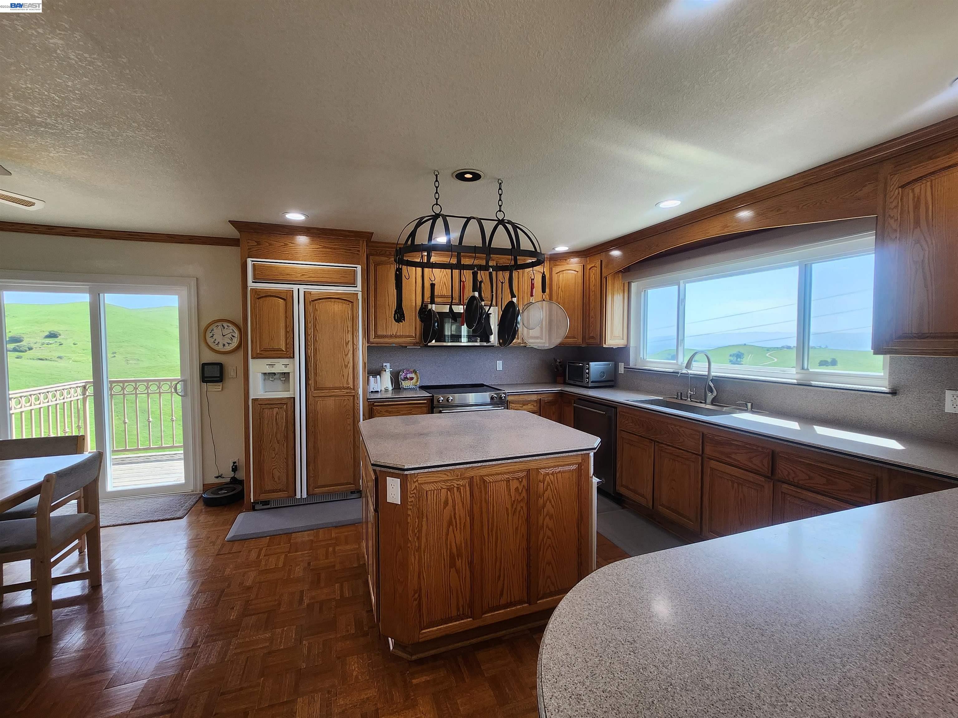 41794 Vargas Road Fremont, CA 94539 - Photo 30 of 60 a kitchen with stainless steel appliances granite countertop a refrigerator a sink dishwasher a stove and a dining table with wooden floor
