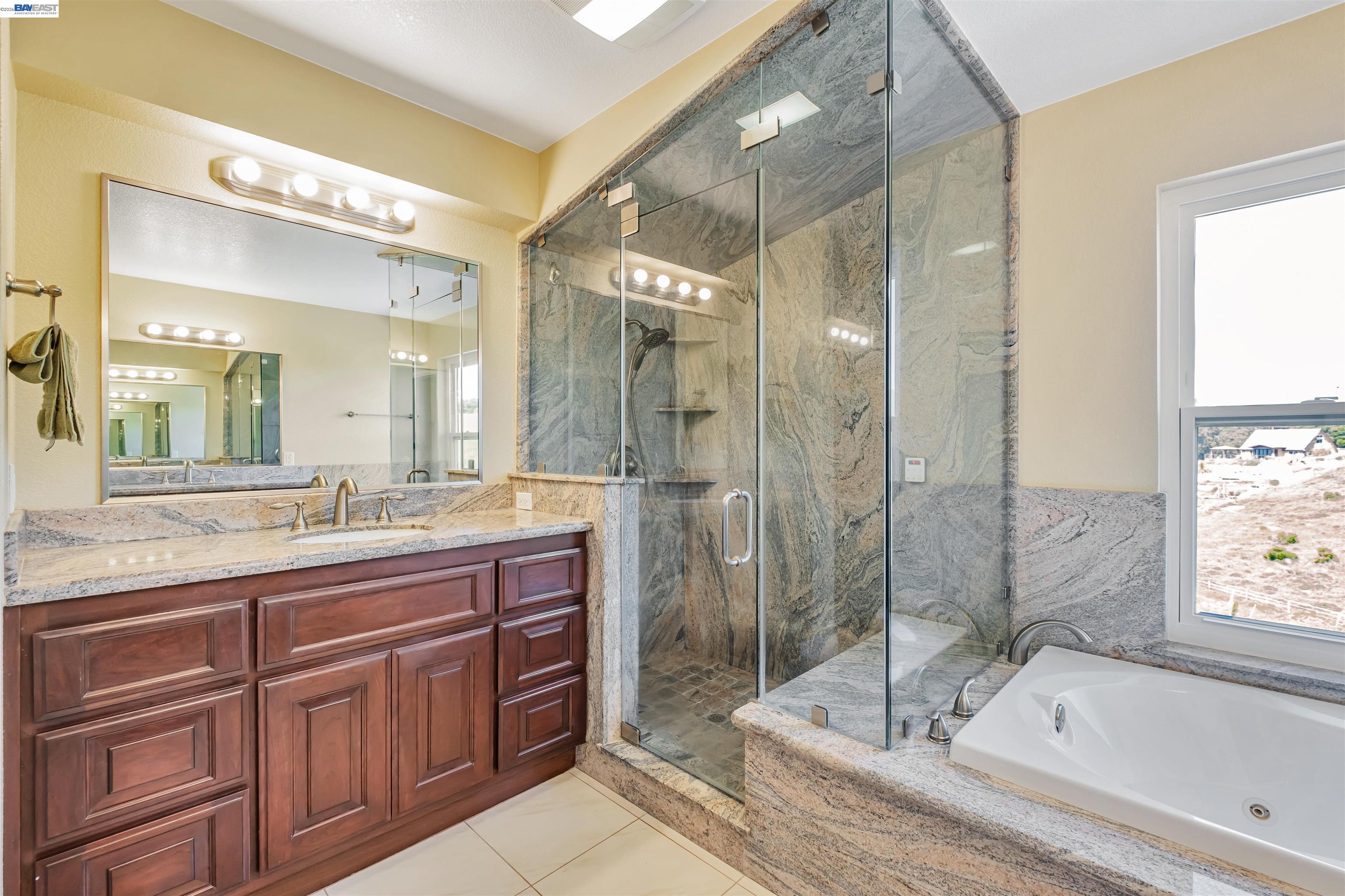 41794 Vargas Road Fremont, CA 94539 - Photo 37 of 60 a bathroom with a granite countertop sink mirror and shower