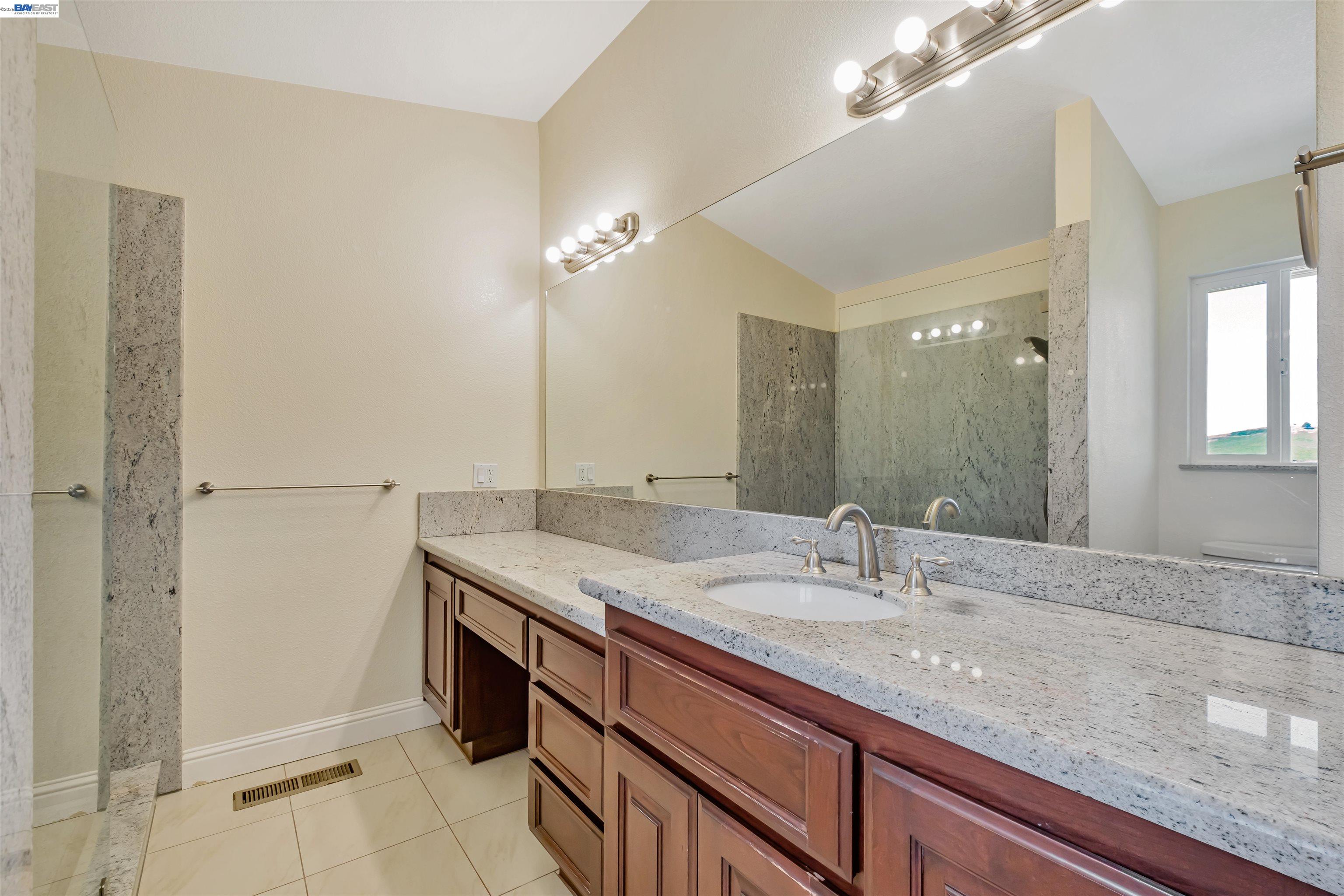 41794 Vargas Road Fremont, CA 94539 - Photo 43 of 60 a bathroom with a granite countertop sink and a mirror