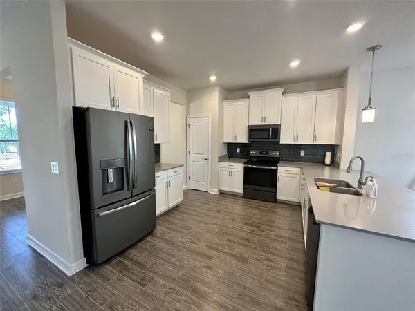 a kitchen with granite countertop a refrigerator and a sink