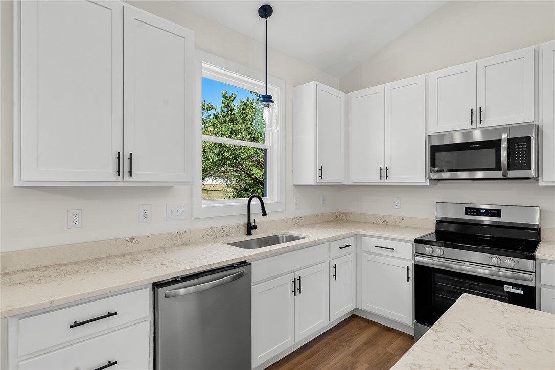 1507 Tindall Avenue Anderson, SC 29621 - Photo 14 of 38 Gleaming stone countertops and shaker cabinetry define this modern culinary workspace with wood flooring.
