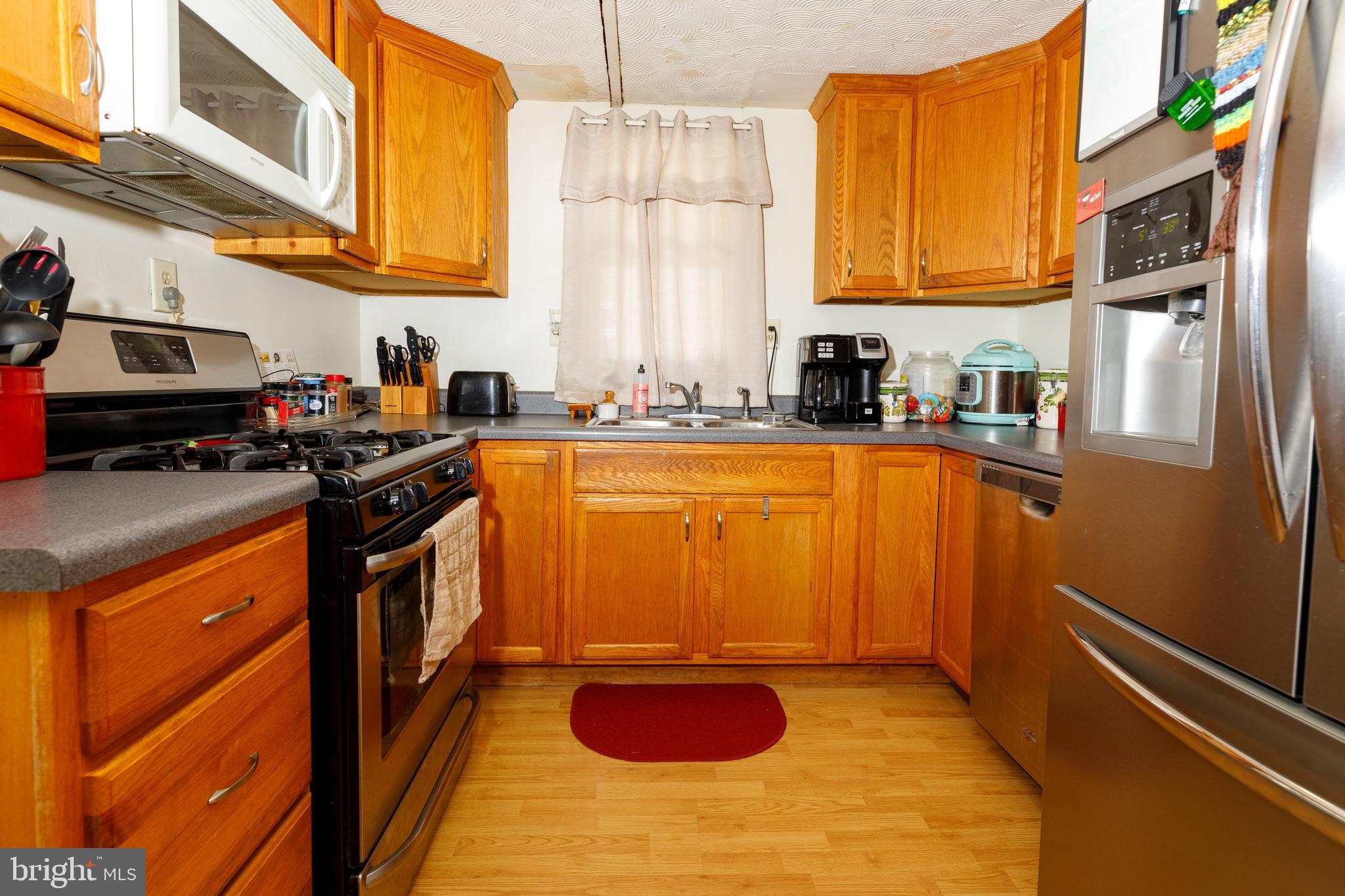 706 Camp Road Denton, MD 21629 - Photo 4 of 20 a kitchen with stainless steel appliances granite countertop a stove a sink and a microwave