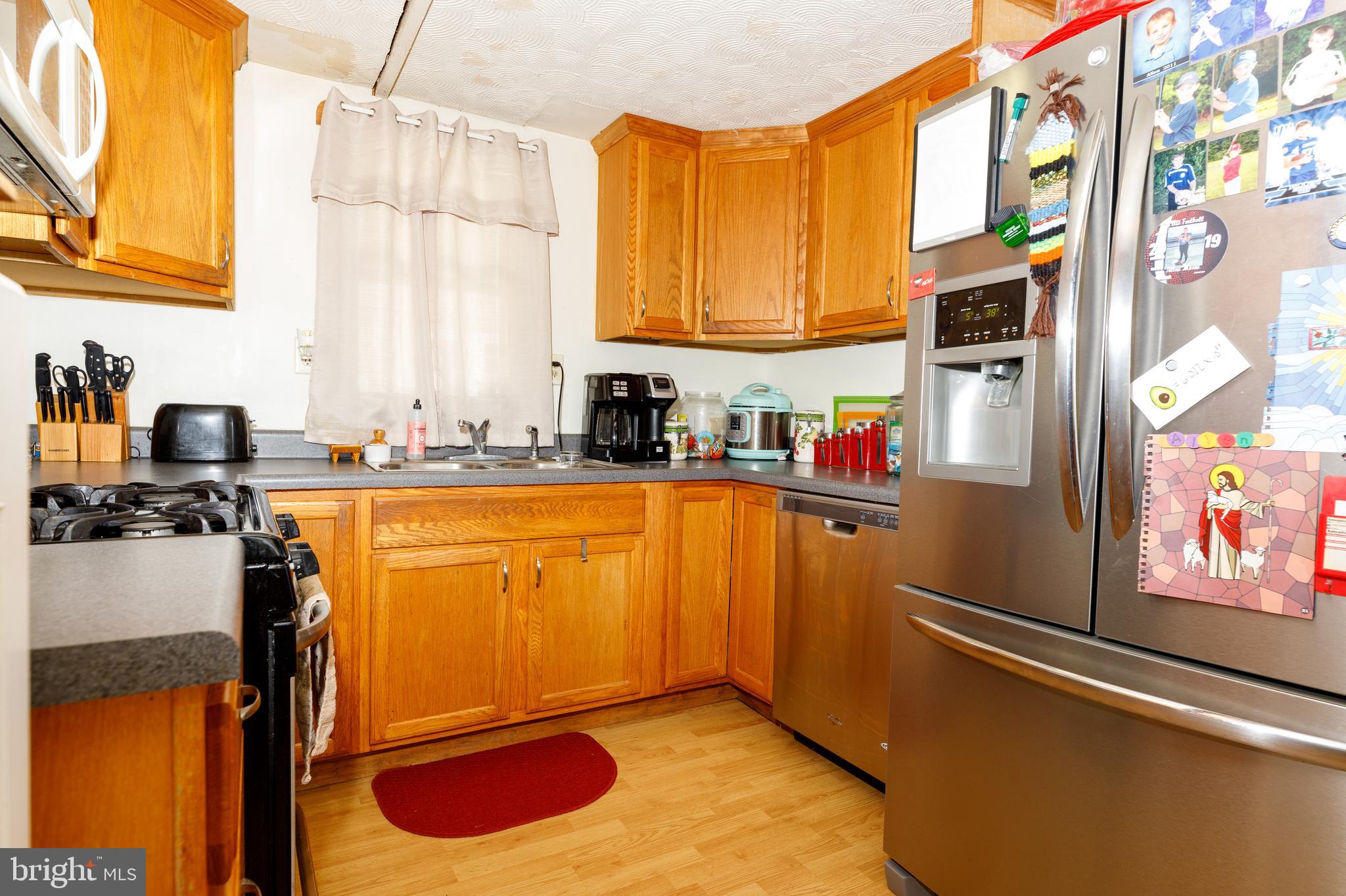706 Camp Road Denton, MD 21629 - Photo 5 of 20 a kitchen with stainless steel appliances a sink and a refrigerator