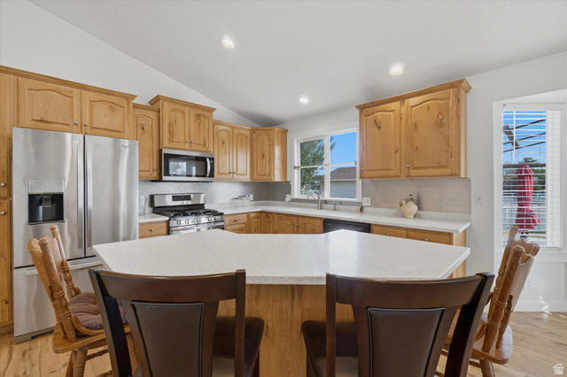 791 East Saddle Road Grantsville, UT 84029 - Photo 7 of 46 Kitchen featuring light wood cabinetry, white countertops, stainless steel appliances, and a central island with seating