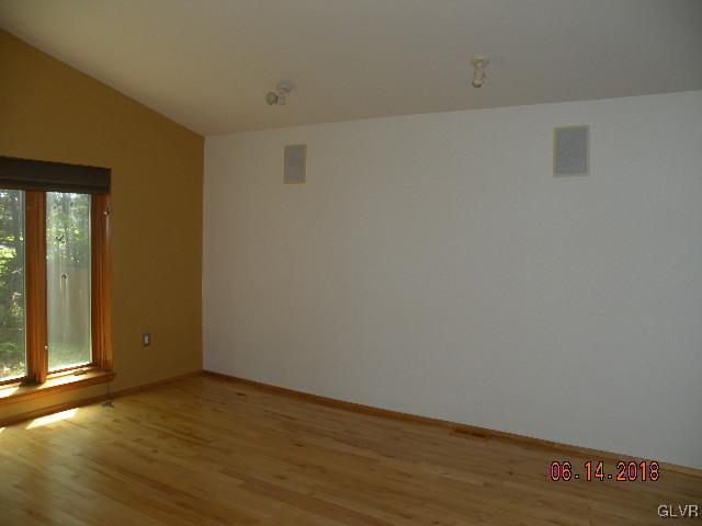 183 Anna Road Pocono Lake, PA 18347 - Photo 3 of 22 an empty room with wooden floor and windows