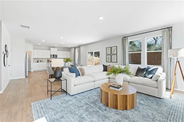 a living room with furniture and view of kitchen