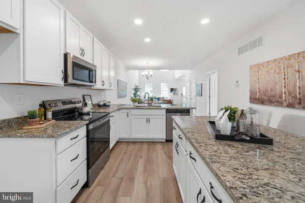 a kitchen with stainless steel appliances granite countertop sink stove top oven and cabinets