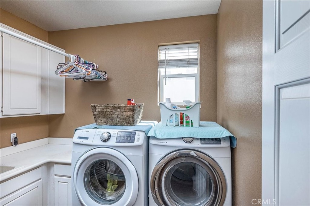31982 Genoa Street Winchester, CA 92596 - Photo 31 of 49 Large indoor laundry room with multiple cabinets and built-in sink.