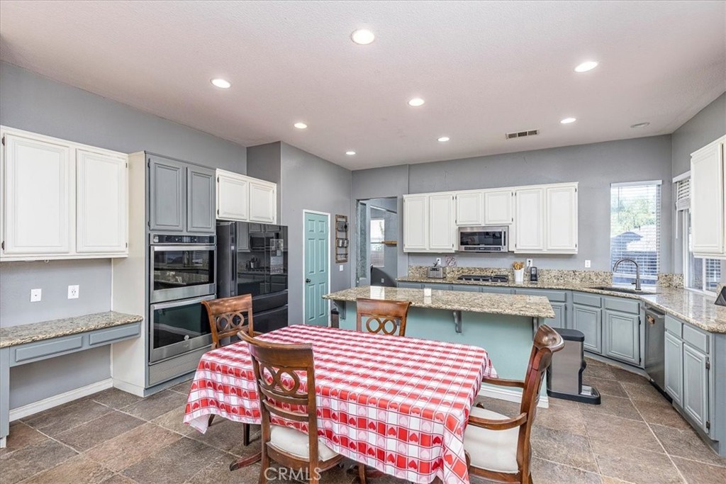 31982 Genoa Street Winchester, CA 92596 - Photo 10 of 49 Looking from family room into breakfast area and kitchen. Granite Countertops, double ovens & microwave. Island/breakfast bar. Pantry.