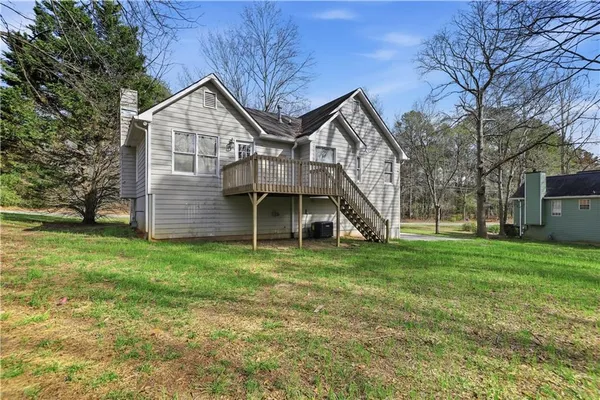 a view of a house with a big yard and large trees