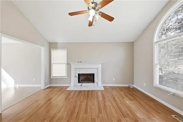 wooden floor fireplace and windows in an empty room