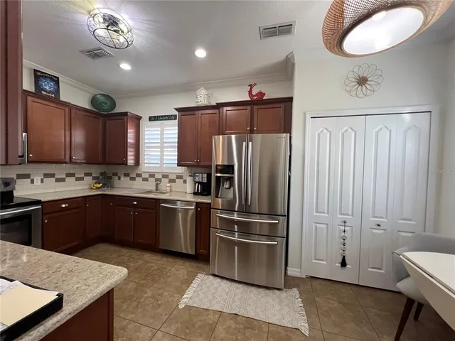 a kitchen with stainless steel appliances granite countertop wooden cabinets a stove top oven a sink and dishwasher