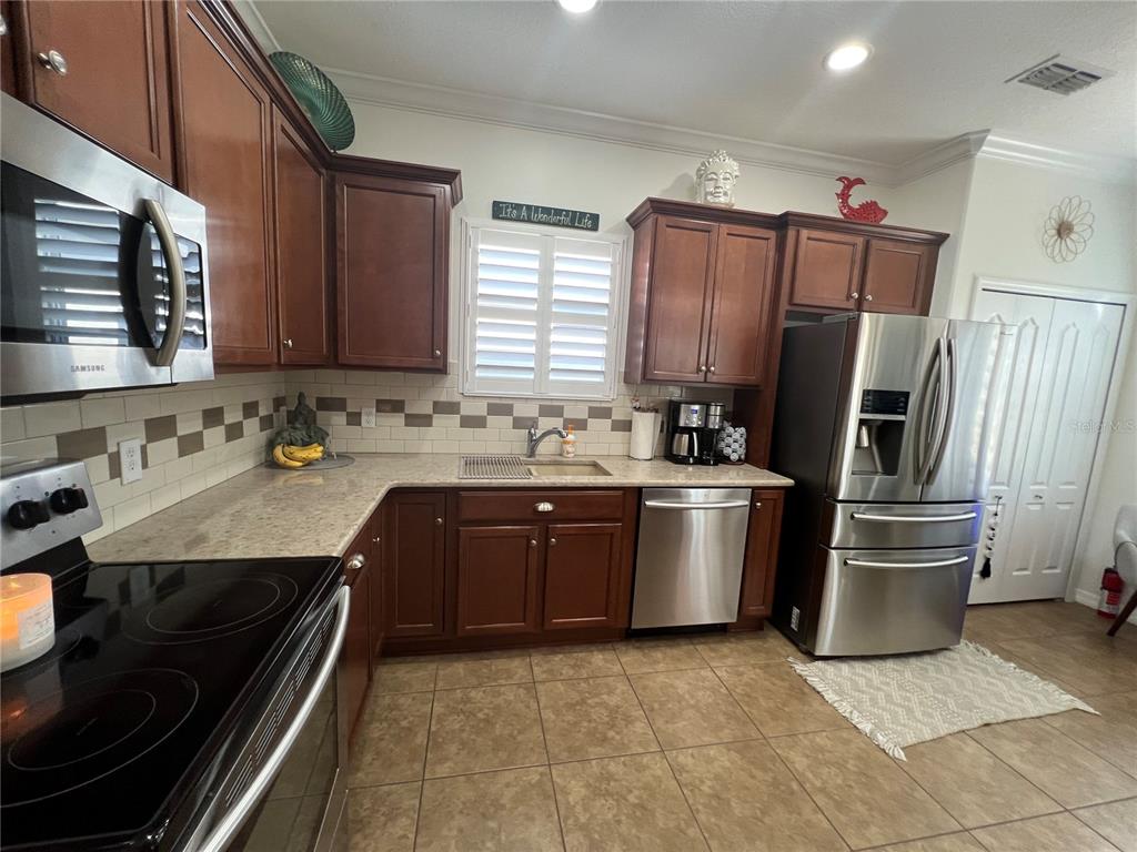 24401 Manchester Trail Port Charlotte, FL 33980 - Photo 22 of 47 a kitchen with a sink stove and refrigerator