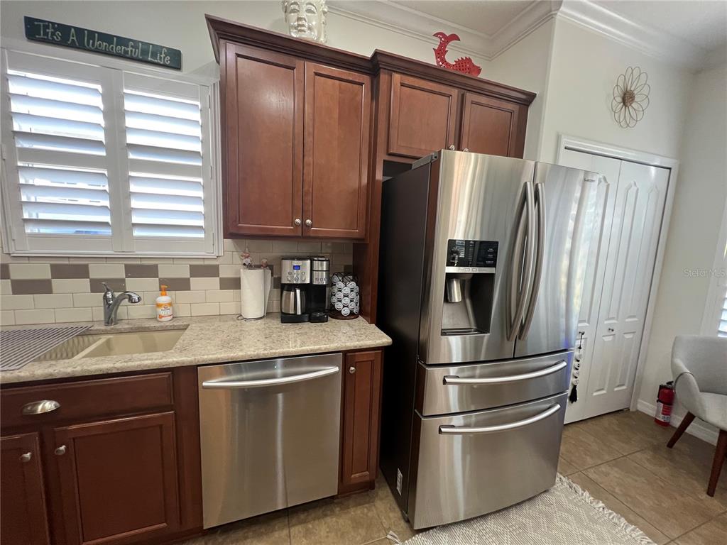 24401 Manchester Trail Port Charlotte, FL 33980 - Photo 23 of 47 a kitchen with stainless steel appliances granite countertop a refrigerator sink and wooden cabinets