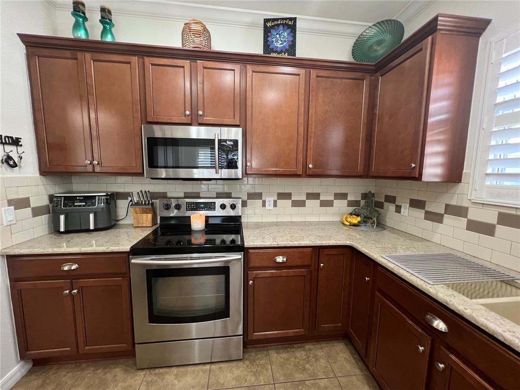 24401 Manchester Trail Port Charlotte, FL 33980 - Photo 24 of 47 a kitchen with granite countertop a sink stove and microwave