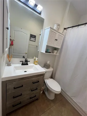 a bathroom with a sink a toilet and shower curtain