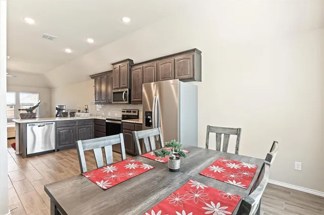a kitchen with a refrigerator a stove a sink dishwasher and wooden floor