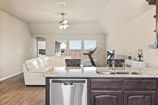 a kitchen with kitchen island granite countertop a white cabinets and chandelier