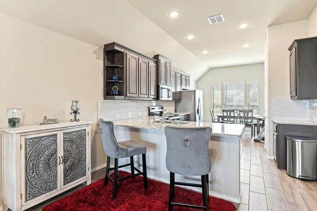 a kitchen with granite countertop a sink appliances and cabinets