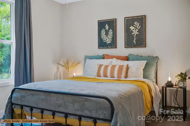 a bedroom with a bed and painting on the wall