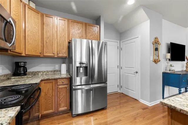a kitchen with stainless steel appliances granite countertop a refrigerator stove and microwave