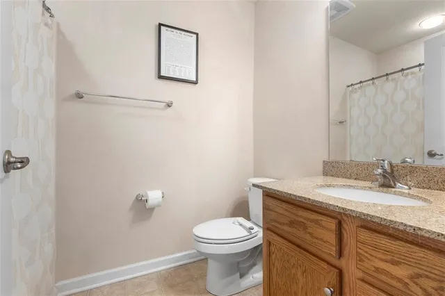 a bathroom with a granite countertop toilet sink and mirror