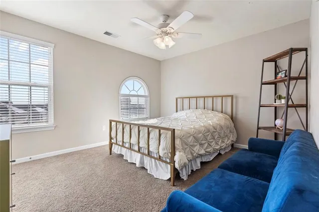 a spacious bedroom with a bed a couch and a window
